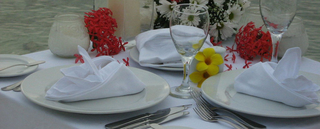 Servietten aus Stoff auf eingedecktem Tisch mit Blumen