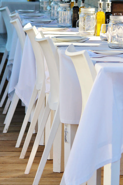 Tischdecken weiss auf dekoriertem Tisch mit weißen Stuehlen