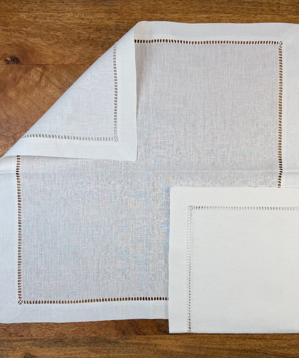 Leinenserviette Riva 50x50cm weiß auf Holztisch dekoriert.