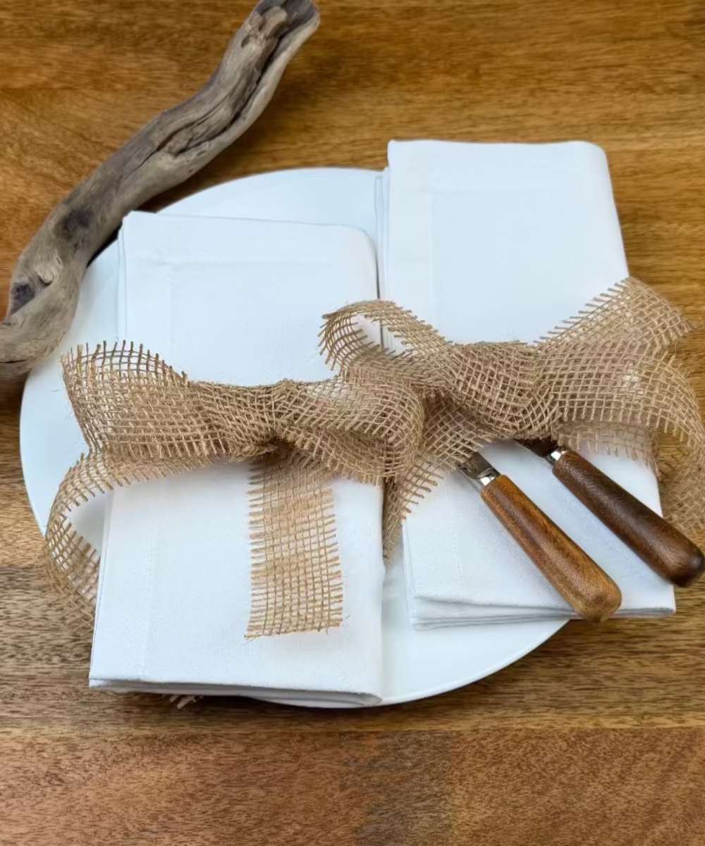 Zwei Stoffservietten Como 50x50c und 40x40cm auf Teller mit Besteck.