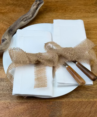 Zwei Stoffservietten Como 50x50c und 40x40cm auf Teller mit Besteck.