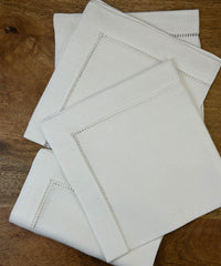 Stoffservietten Finca 50x50cm handgestickt mit Hohlsaum auf Holztisch.