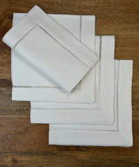 Stoffservietten Finca 50x50cm handgestickt mit Hohlsaum auf Holztisch.