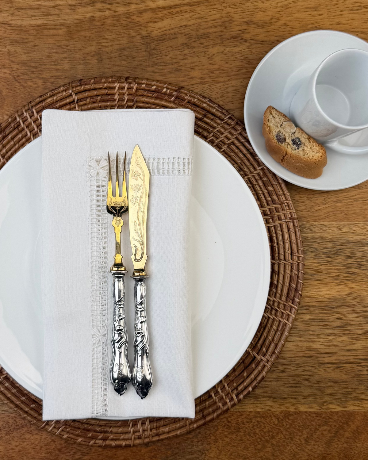 Stoffserviette weiß Fiorenze auf Teller mit Kuchenbesteck und Kaffeetasse dekoriert.