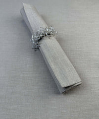 Stoffserviette Keitum 50x50cm Farbe Sand mit Serviettenring aus weißen Glasperlen.