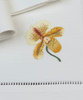 Nahaufnahme des gestickten Motivs derStoffservietten Orchideen 50x50cm handgestickt mit Hohlsaum.