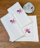 Stoffservietten Orchidee Rosa 50x50cm handgestickt mit Hohlsaum auf Holztisch mit Kaffeetass eingedeckt.