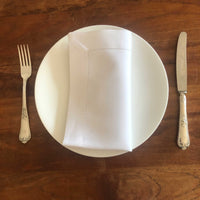 Stoffservietten 45x45cm auf einem weißen Teller mit Besteck, elegant gedeckte Tafel.