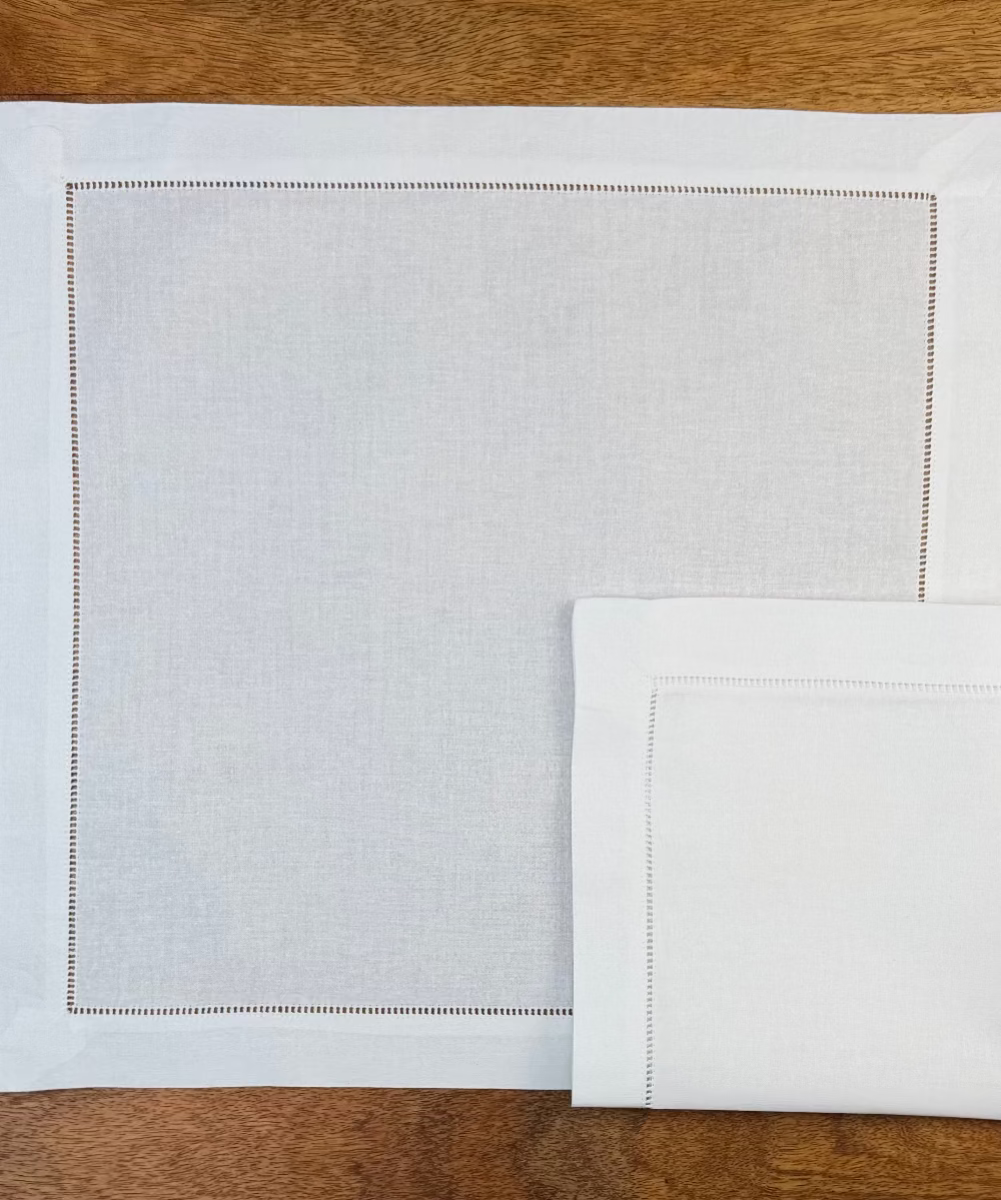 Zwei Stoffservietten weiss Toscana auf Holztisch.