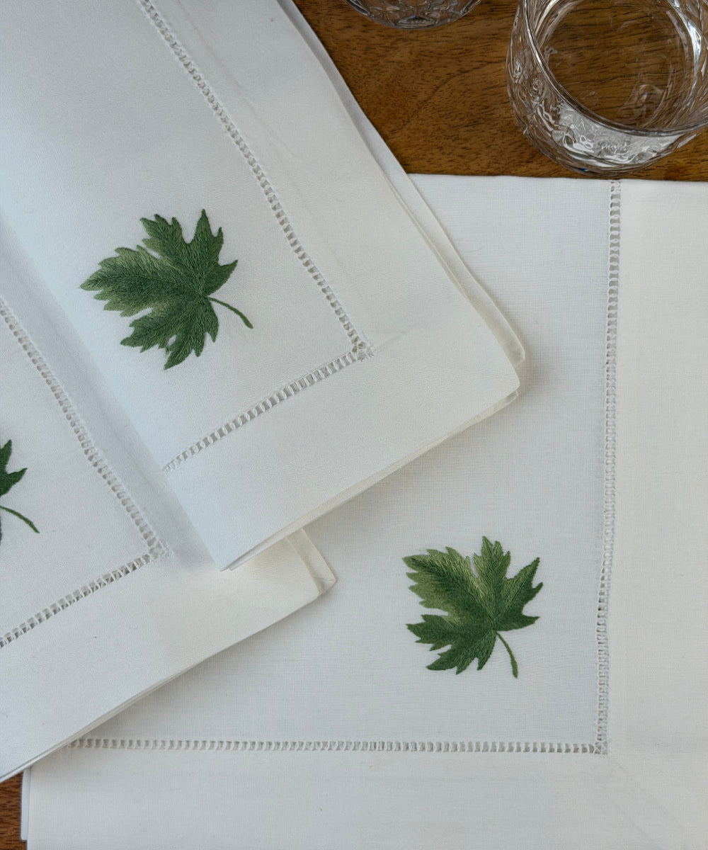 Stoffservietten Ahorn 50x50cm handbestickt und mit Gläsern auf Holztisch dekoriert.