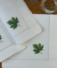 Stoffservietten Ahorn 50x50cm handbestickt und mit Gläsern auf Holztisch dekoriert.