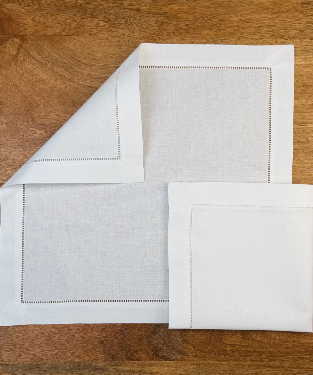 Zwei Stoffservietten weiß Toscana 40x40cm auf Holztisch.