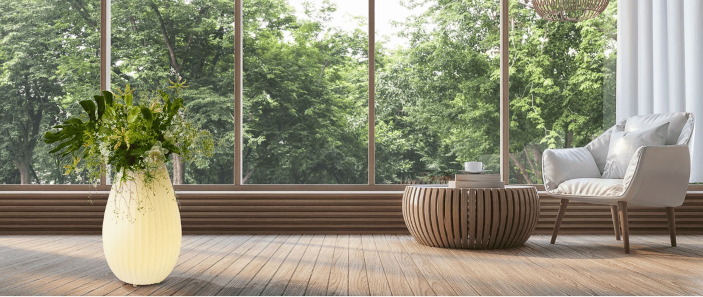 The Joouly als Blumengesteck  in lichtdurchflutetem Wohnzimmer mit Blick in den Garten in szene gesetzt.