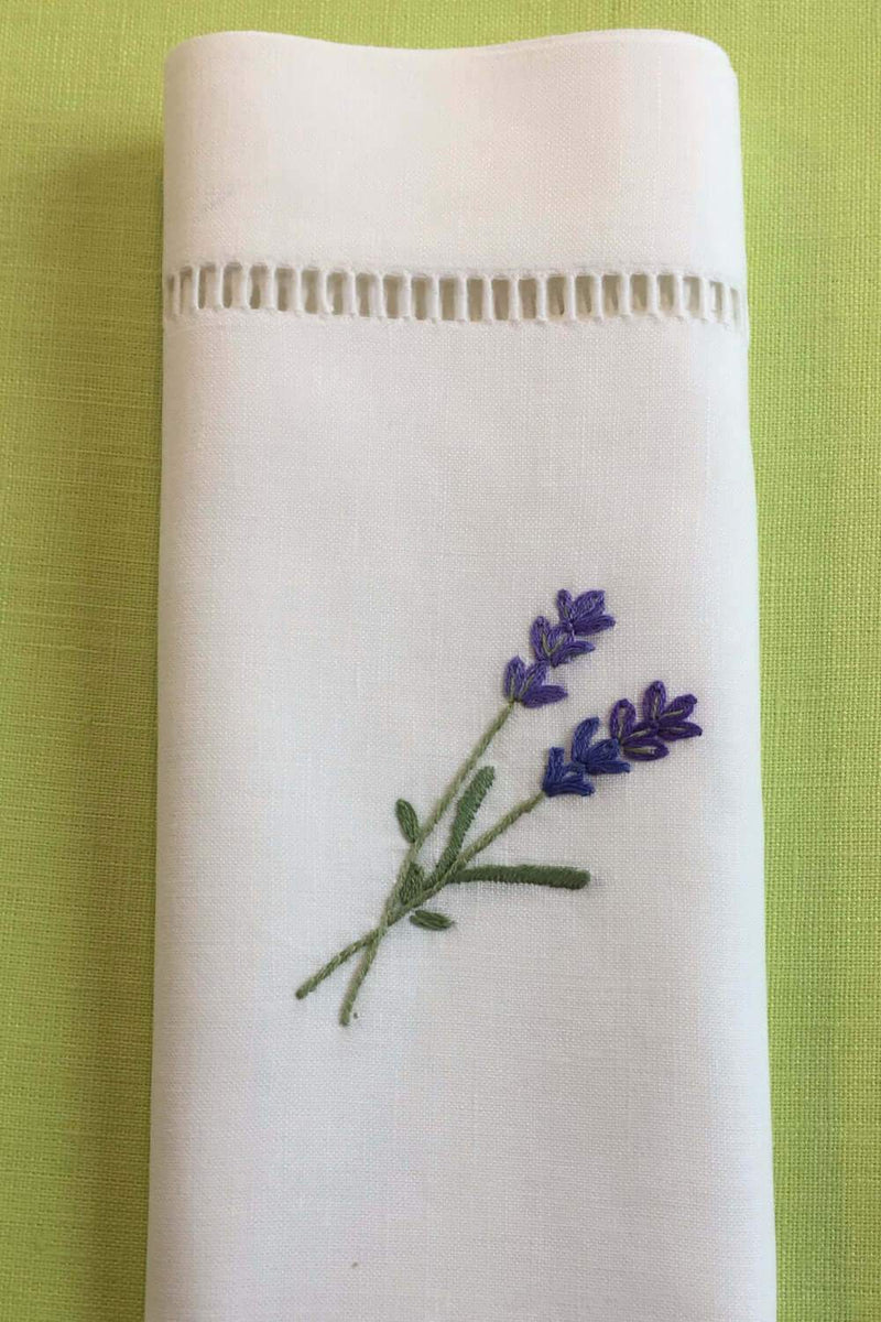 handgestickte Lavendel Zweige auf einer weißen Serviette aus Halbleinen mit Hohlsaum