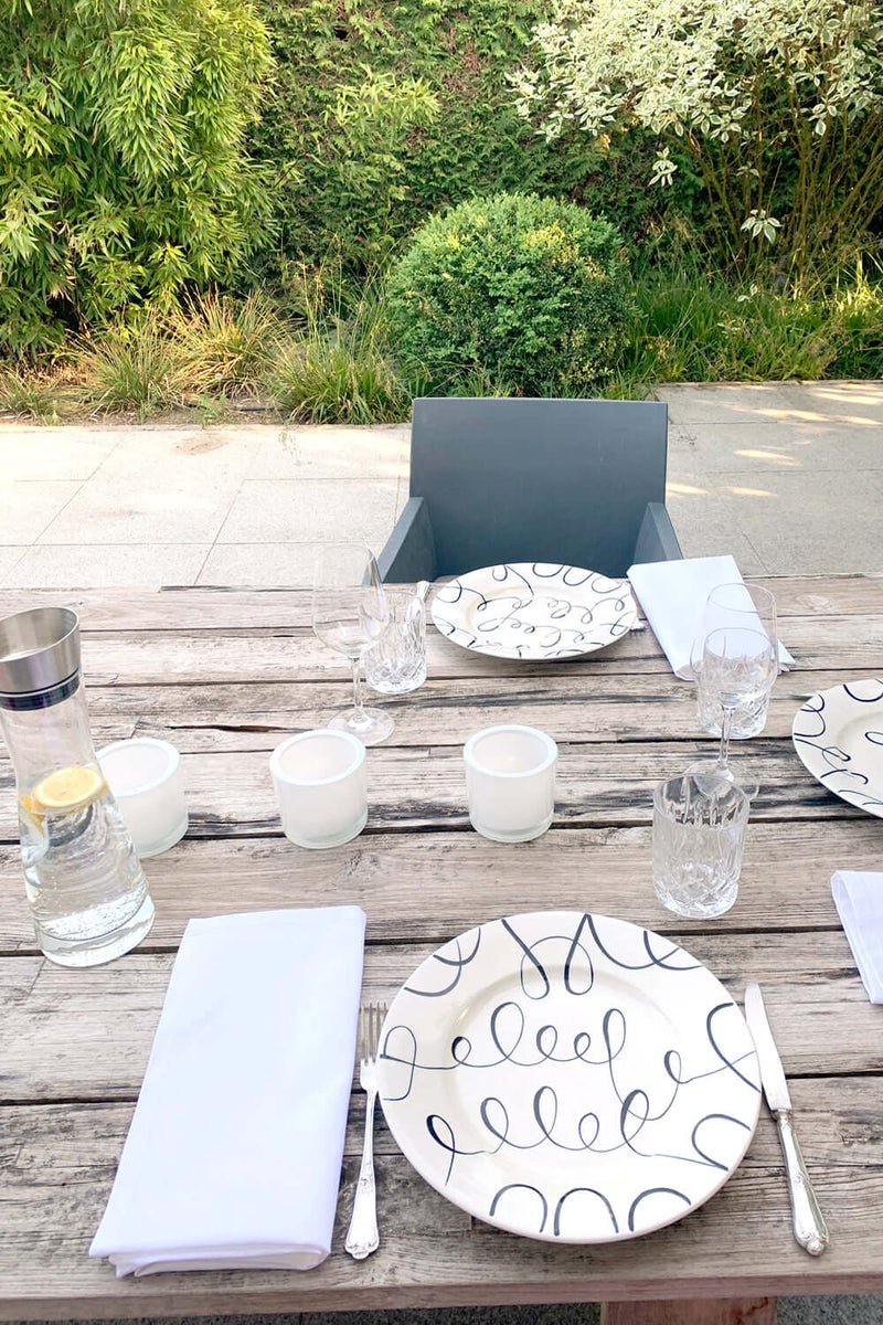 Verona 50x50cm Serviette aus weißer Baumwolle  auf Esstisch im freien mit Tellern und Gläsern  zum Feiern dekoriert