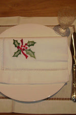Luxuriöse Weihnachtsservietten-Serviette aus weißem Halbleinen mit weihnachtlichem Ilex Motiv und handgesticktem Hohlsaum Abschluss 