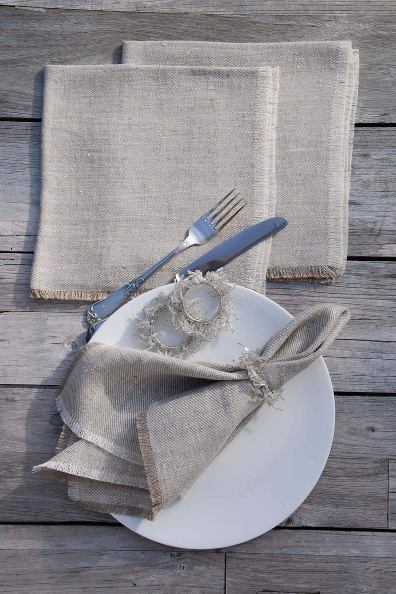 Leinenservietten natur, sehr trendy mit Fransenabschluss auf gedecktem Teaktisch photographiert