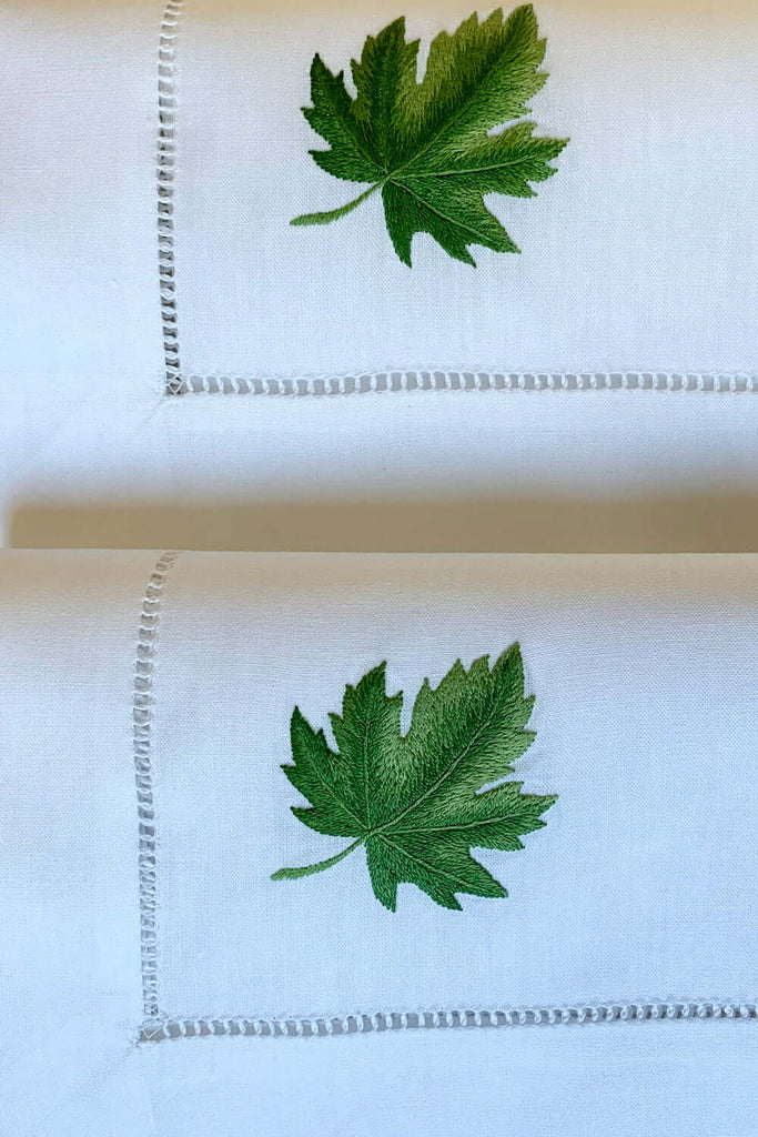 Von Hand gesticktes Ahornblatt in schönen Grüntönen auf 50x50cm Stoffserviette mit Hohlsaum-Beste Online-Stoffservietten mit Ahorn auf Deutsch.